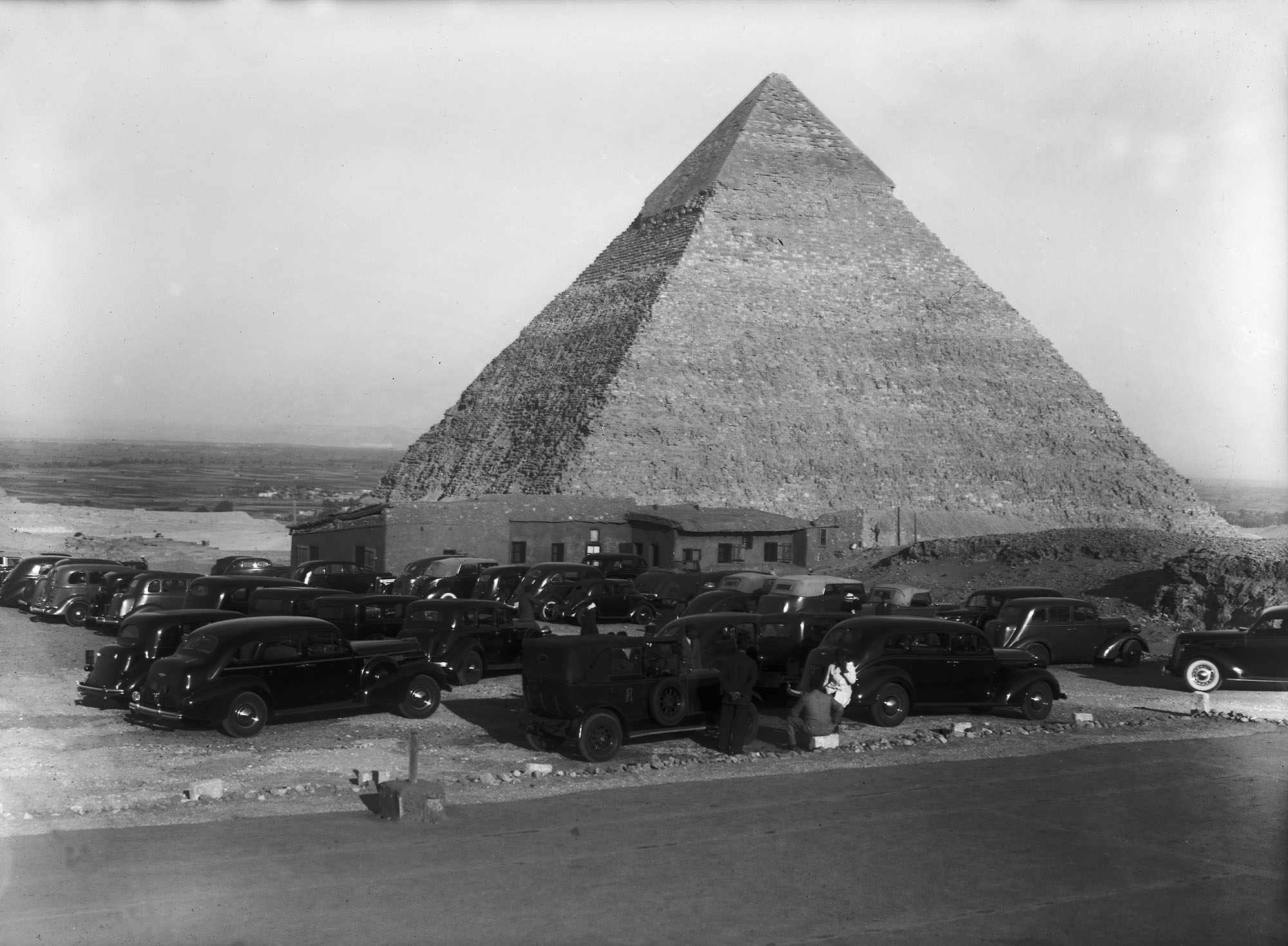 cars parked around base of harvard camp close to pyramid.