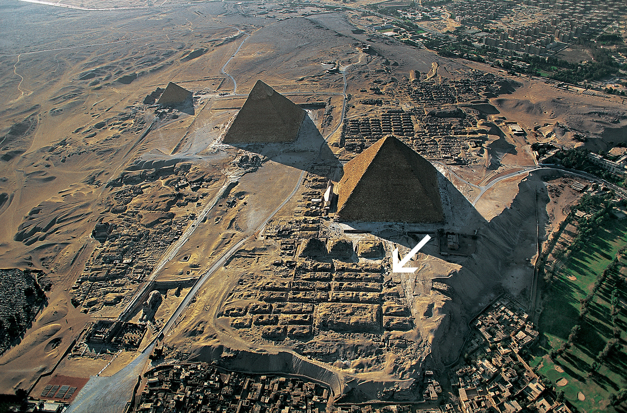 aerial view of giza plateau with arrow marking location of idu's tomb near pyramid.
