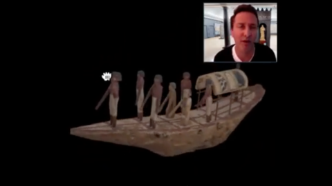 curator and model of river boat with canopy and six standing figures.