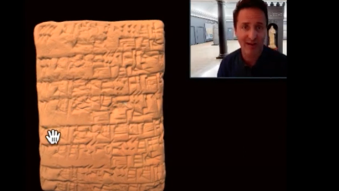 curator and cuneiform tablet.