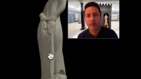 curator and headless prisoner statue with hands bound behind back.