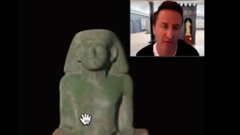 curator with statue of torso and head.