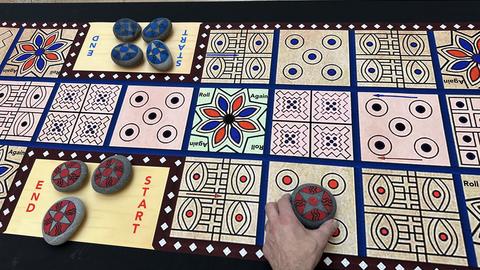 A visitor playing a colorful ancient game