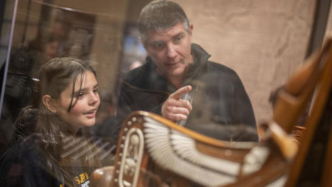 A pair of guests point at a display case.