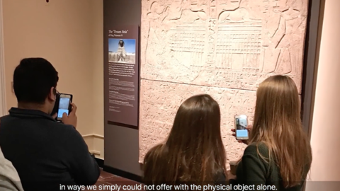 visitors in gallery view dream stela augmented reality on their phones.