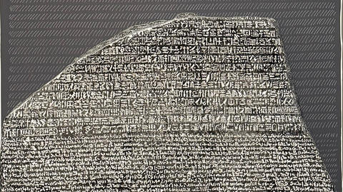 top of rosetta stone shows hieroglyphs and one other writing.