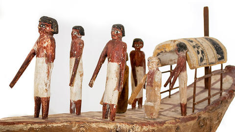 Ancient Egyptian model a boat with people on it.