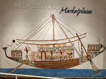 Painting of an ancient boat with people and goods on it.