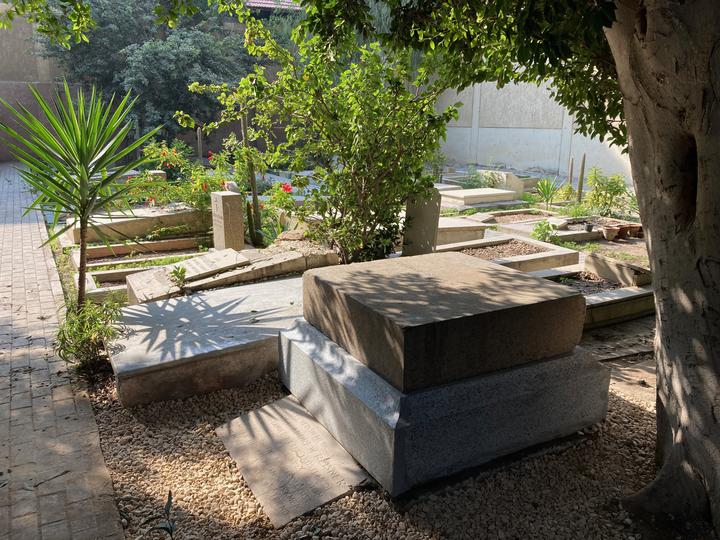 A cemetery with lush trees and shrubs.