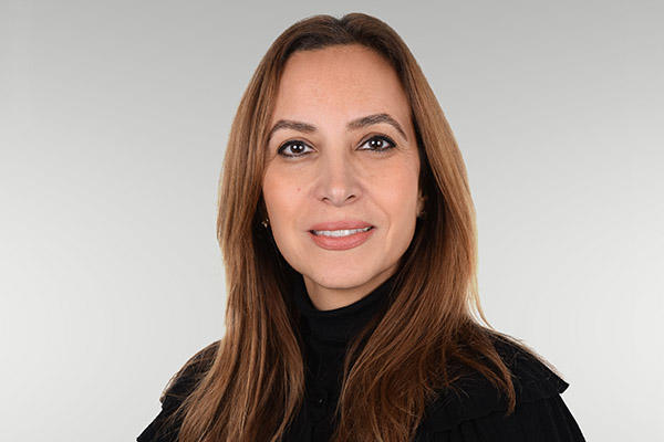 Speaker Yasmin El Shazly in a black shirt, smiling.
