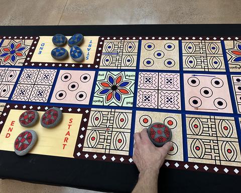 A visitor playing a colorful ancient game