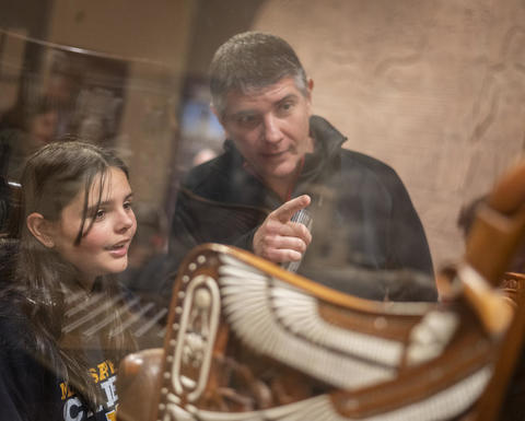 A pair of guests point at a display case.