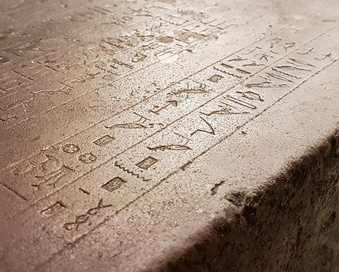 A stone with heiroglyphic markings.